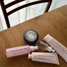Beauty Pie Japan Fusion skincare products laid out on a wooden table