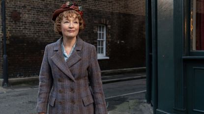 Mrs. Harris (Lesley Manville) stands in a London street in a still from "Mrs. Harris Goes To Paris"