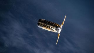 A metal spacecraft with two solar panels on either side is seen in low-Earth orbit