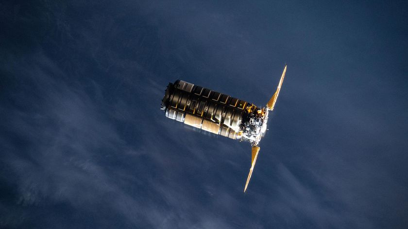 A metal spacecraft with two solar panels on either side is seen in low-Earth orbit