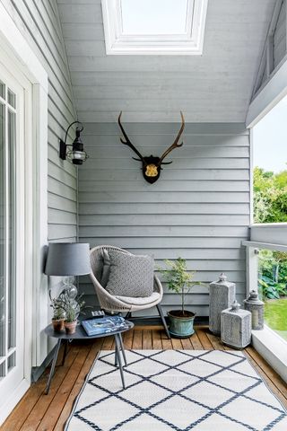 Small balcony with a chair, wall lighting and rug