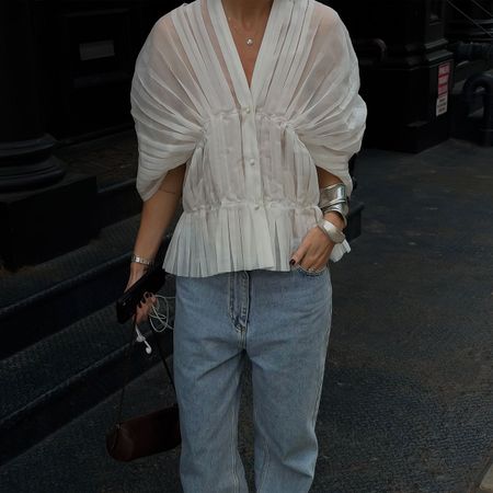 @hannahlewisstylist outfit closeup in a white pleated blouse and baggy blue jeans