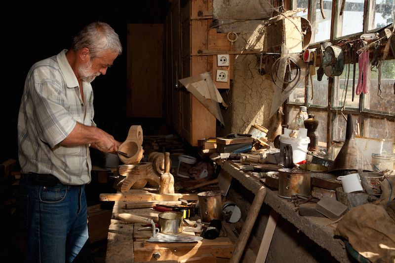 An older man works with wood