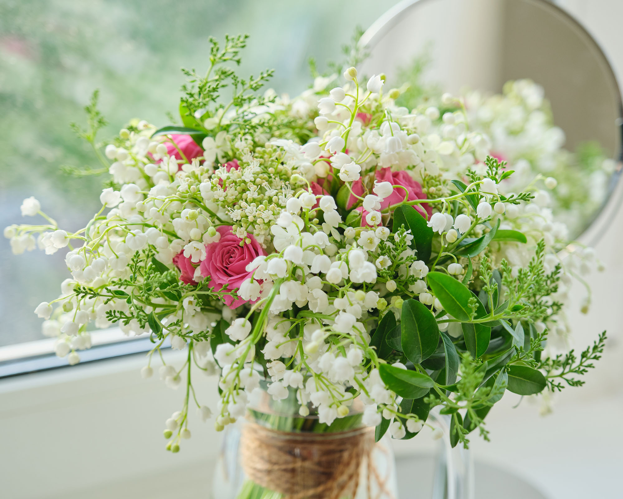 Springtime, spring fresh bouquet of lilies of the valley, pink roses, blooming viburnum.