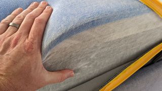 A hand squeezing the edge of the Emma Zero Gravity mattress