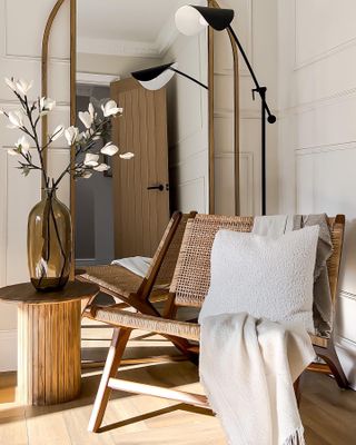 A wicker chair next to a wooden side table