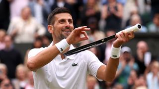 Novak Djokovic of Serbia mimes playing his tennis racquet like a violin to antagonize the All England Club crowd ahead of the Alcaraz vs Djokovic Wimbledon final 2024 