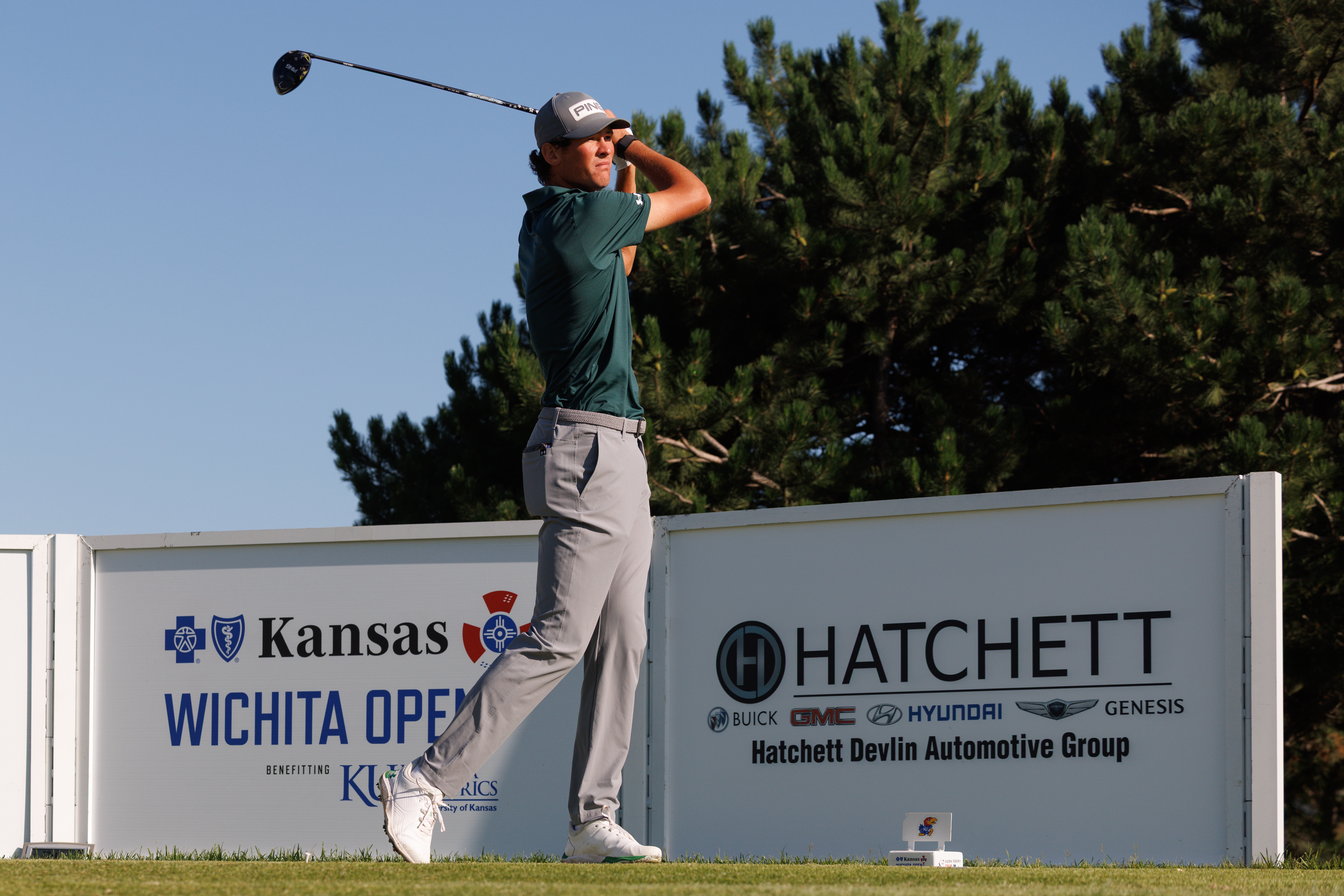 Christo Lamprecht holds his finish on a drive in front of a Kansas Wichita Open sign