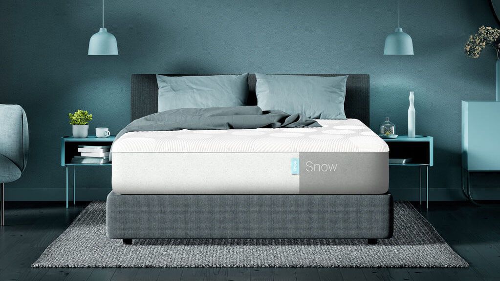 Casper Snow mattress review: Image shows the Casper Snow mattress placed on a light grey bed frame in a blue and green bedroom