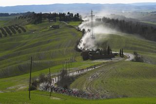 SIENA ITALY MARCH 06 The Peloton passing through a gravel strokes sector during the Eroica 15th Strade Bianche 2021 Mens Elite a 184km race from Siena to Siena Piazza del Campo Tuscany Dust Landscape StradeBianche on March 06 2021 in Siena Italy Photo by Tim de WaeleGetty Images