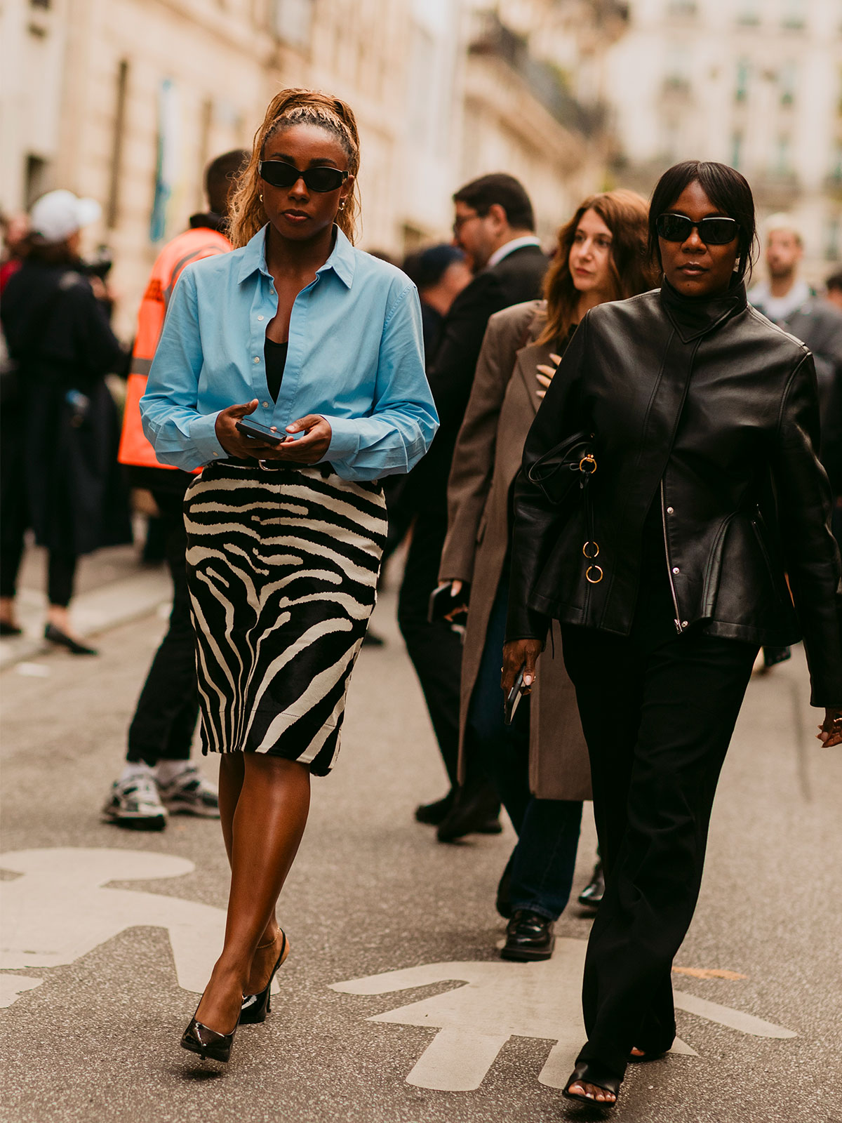 Woman wearing a blue button-down and zebra print midi skirt.
