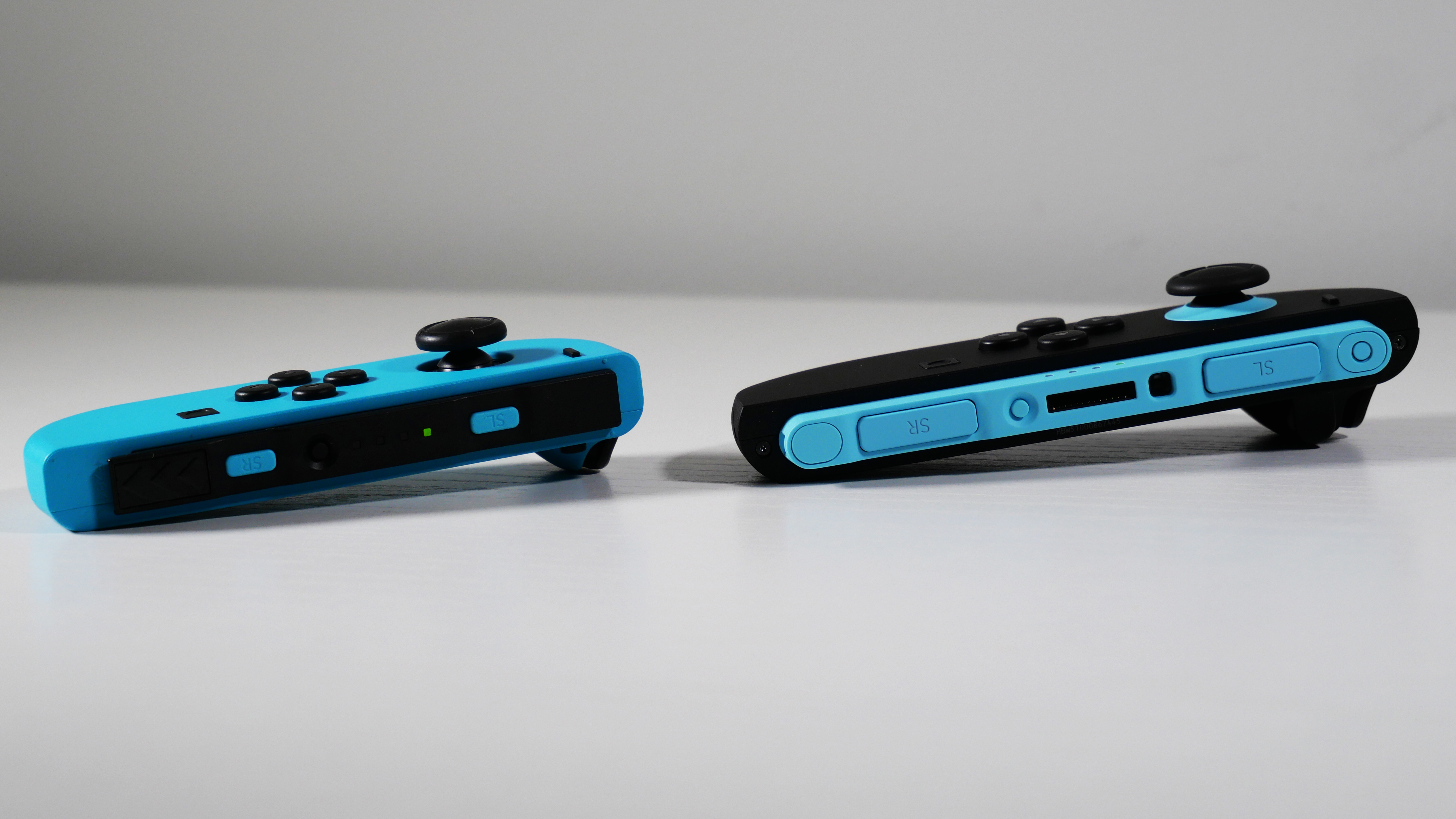Nintendo Switch 2 and Switch OLED Joy-Con controllers side by side, highlighting their detached bits.