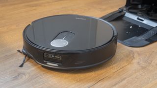 Roborock Qrevo Slim robot vacuum emerging from its dock