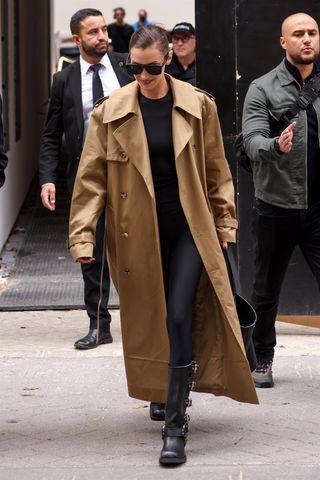 Bella Hadid wears a brown trench coat with black moto boots while in Paris.