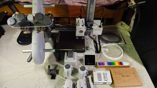 A picture of the A1 Mini, AMS Lite and parts, tool kit, filament swatches, sample filament, and lamp kit.