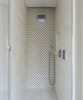 A small wet room with monochrome tiles