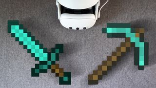 A Meta Quest 3 headset alongside a diamond sword and diamond pickaxe from Minecraft