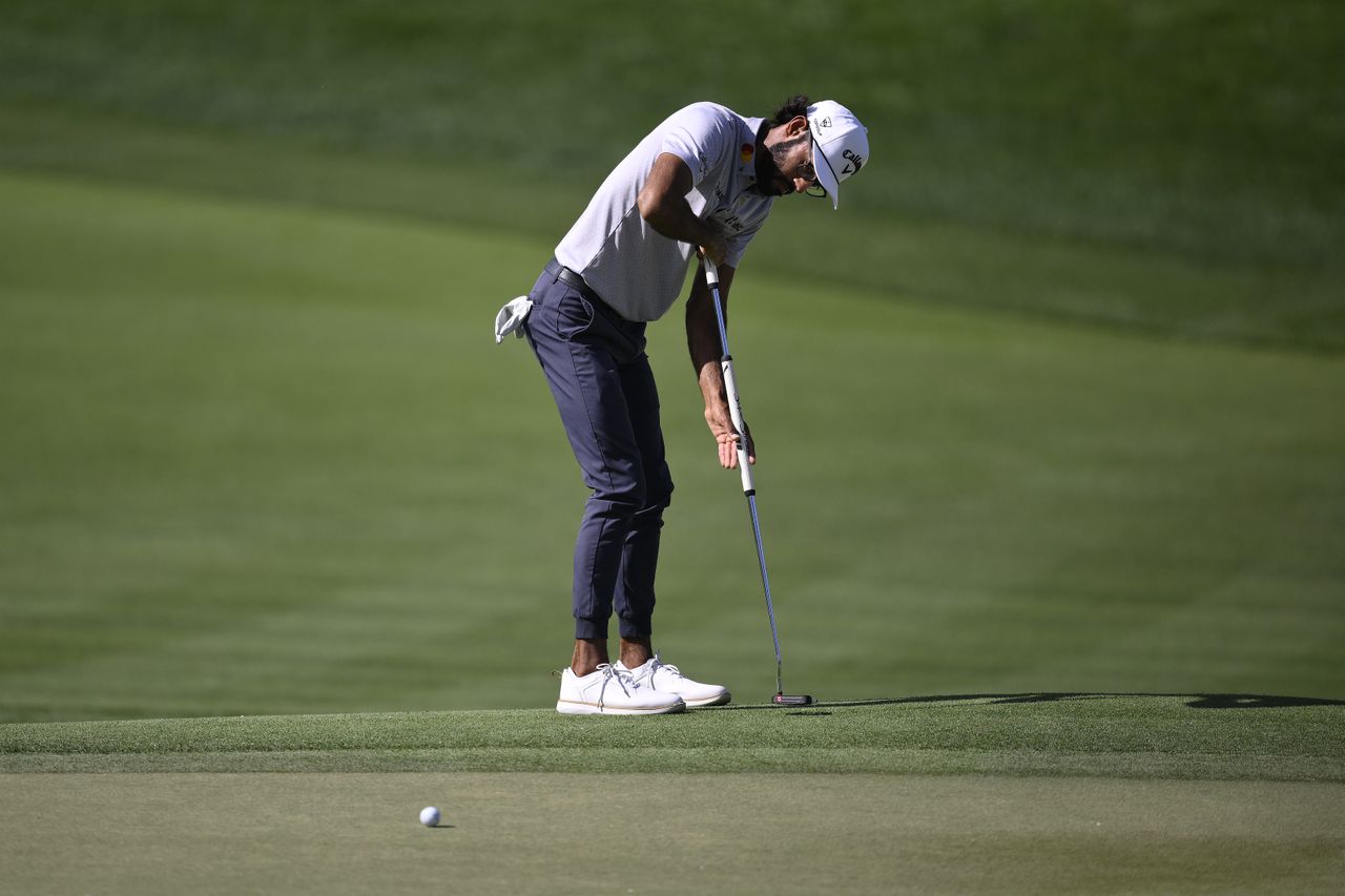 Akshay Bhatia hits a putter