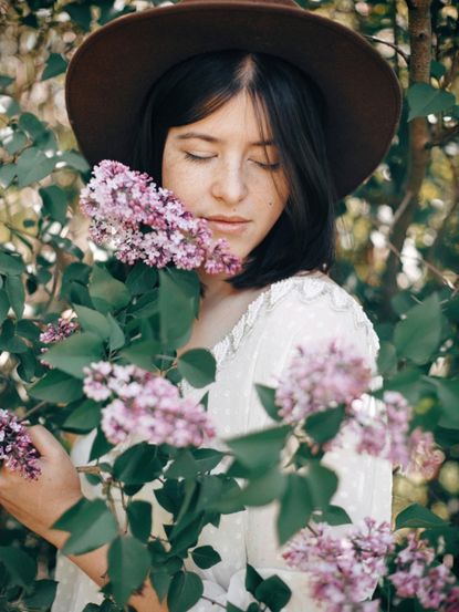 Person Standing Between Lilac Trees