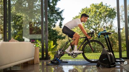  Image shows a cyclist riding one of the best smart turbo trainers. 