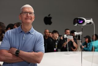 A photo of Apple CEO Tim Cook standing next to the Apple VisionPro headset