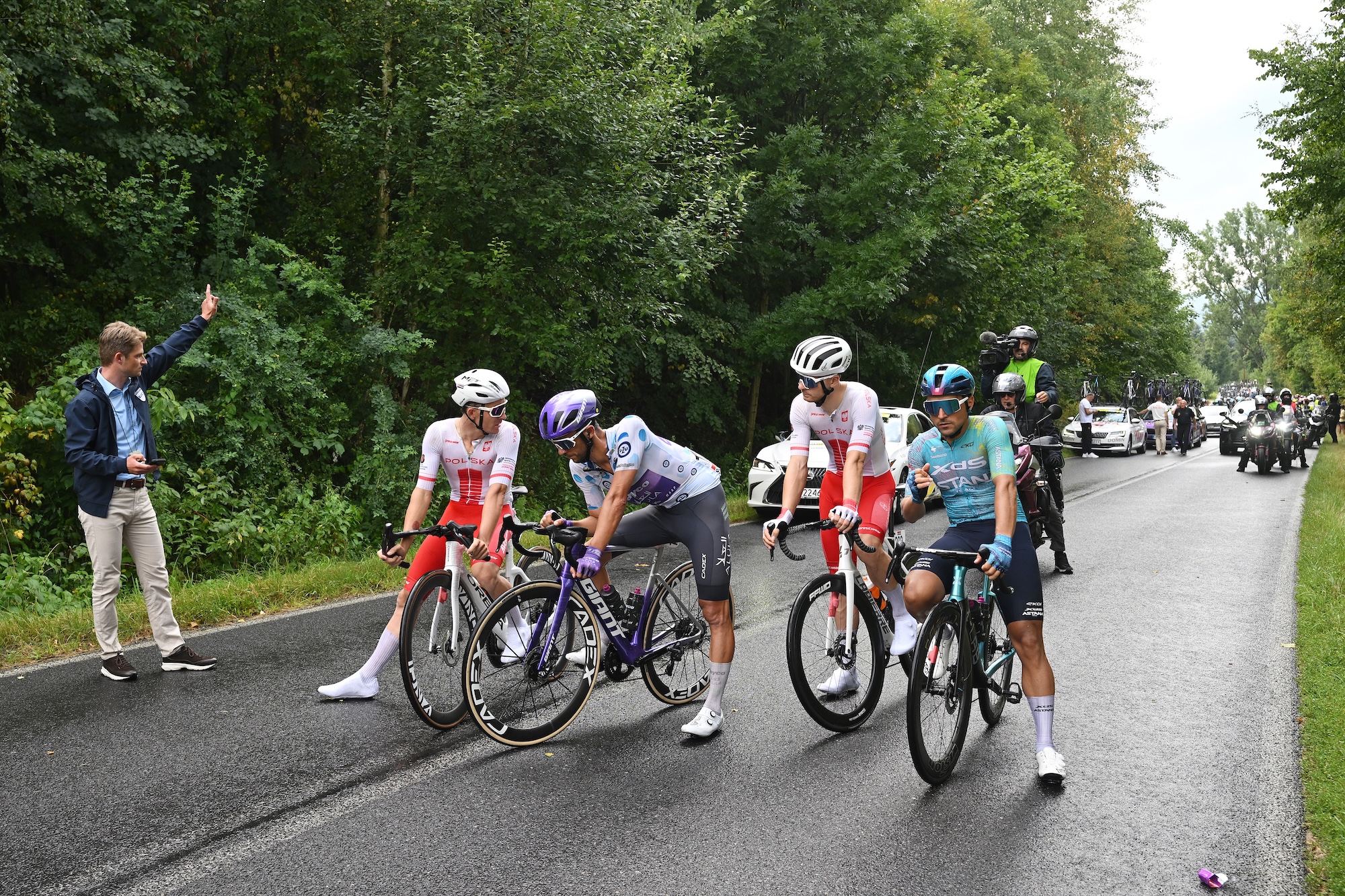 Breakaway riders Patryk Stosz of Team Poland, Dries De Bondt of Jayco AlUla, Tobiasz Pawlak of Team Poland and Matteo Malucelli of XDS Astana start again after the race neutralisation