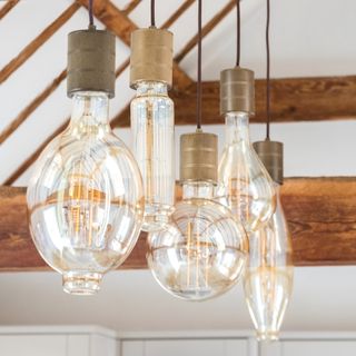 Close up of the varied large lightbulbs suspended above the kitchen island from the vaulted ceiling