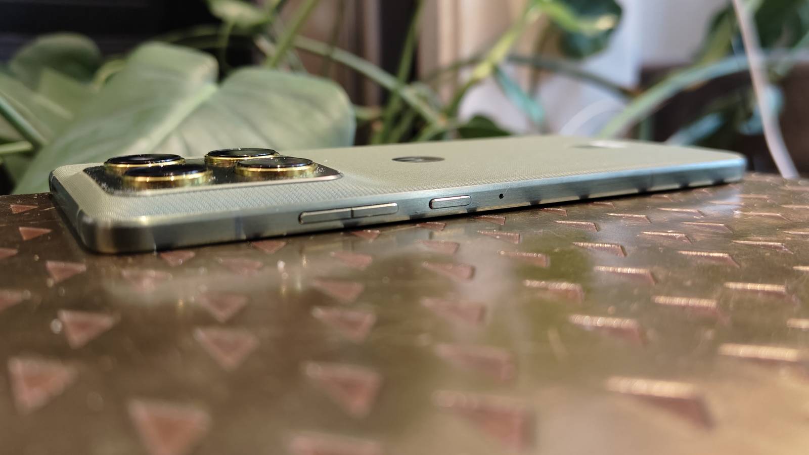 The Motorola Edge 70 face-down on a brown table.