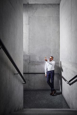 Kandoblanc Aga whisky founder in concrete building holding a glass