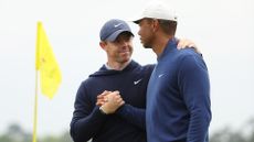 Rory McIlroy of Northern Ireland and Tiger Woods of the United States shake hands on the 18th green during a practice round prior to the 2023 Masters Tournament at Augusta National Golf Club