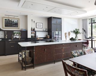 Large kitchen island size illustrated in a white room with black cabinetry.