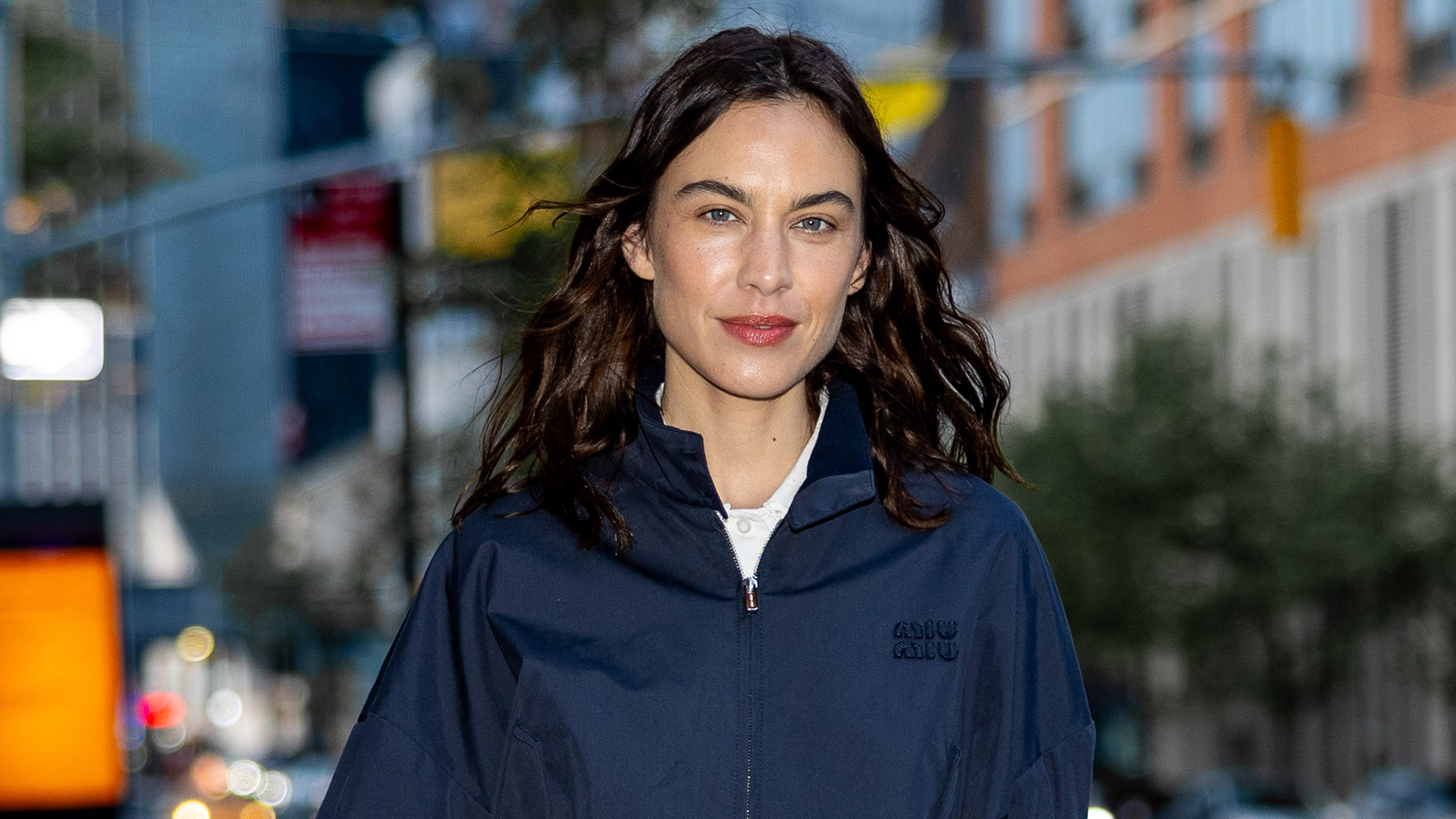 Alexa Chung wearing a navy Miu Miu bomber jacket.