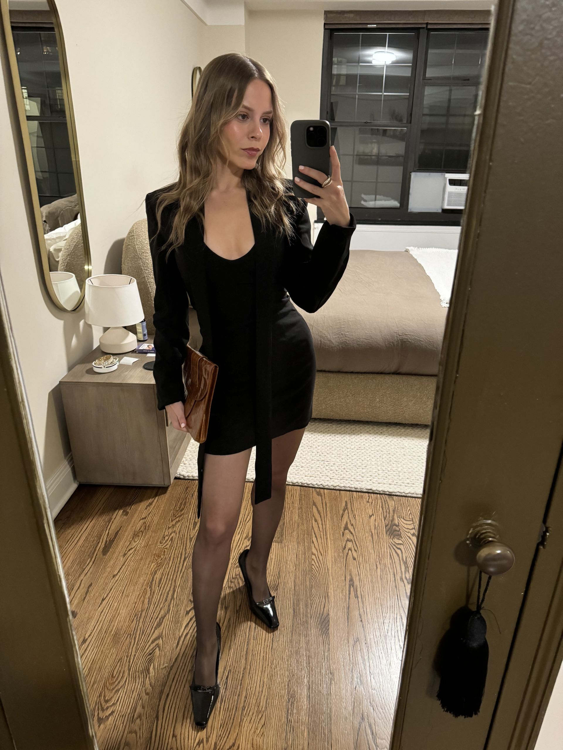 Nikki chwatt wears sheer brown wolford tights and a black minidress.