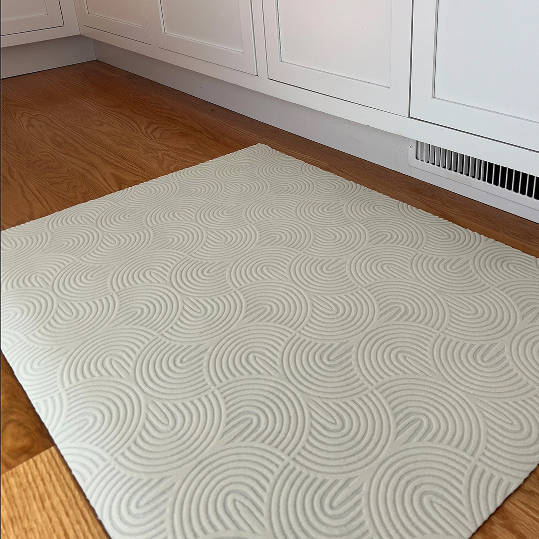 Half circle patterned white rug shown indoors