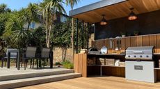 how to design an outdoor kitchen: covered kitchen space with modern patio and dining area