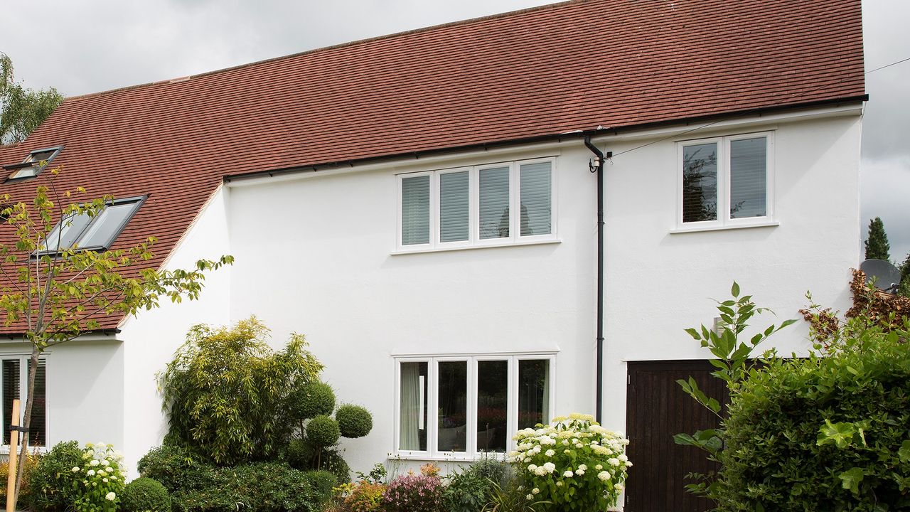 house exterior with white wall white window red roof and plants