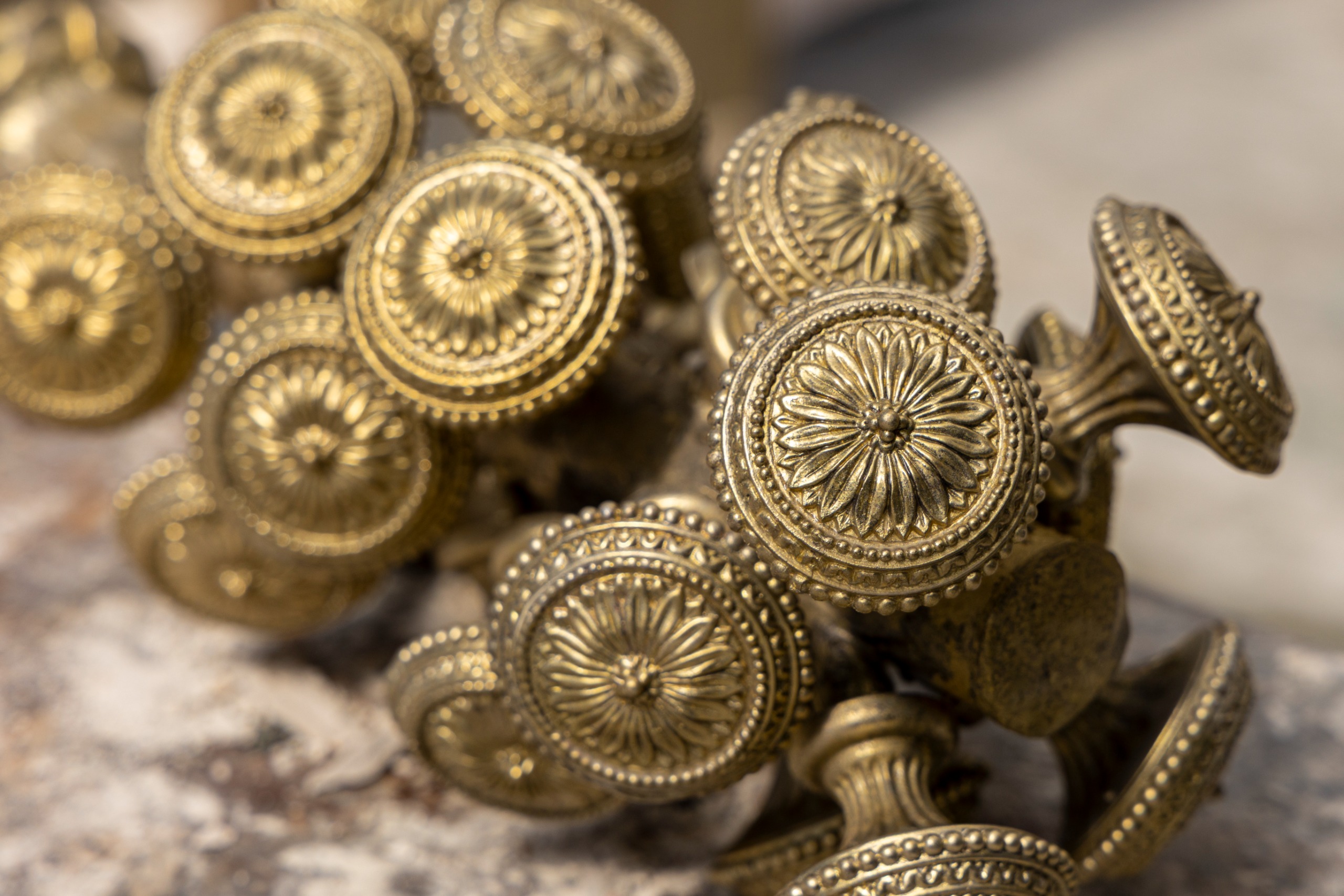 Pile of gold-tone knobs with delicate gold detailing