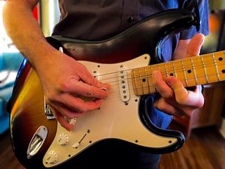 A human bends notes on a 2006 Fender Highway One Stratocaster.