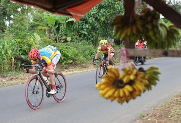 Tour de Singkarak peloton passes a banana kiosk. Payakumbuh, West Sumatra is famous for its agricultural production and farming.