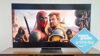 TCL QM8K on stand in living room with deals tag