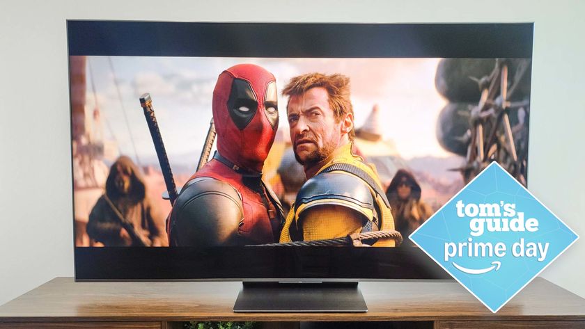 TCL QM8K on stand in living room with deals tag