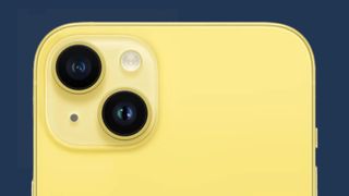 Den övre delen av baksidan på en gul iPhone 14 mot en blå bakgrund.