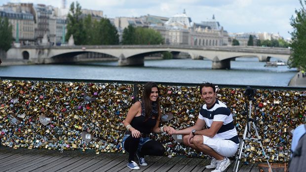 A couple pose with &amp;#039;lovelocks&amp;#039; on a Parisian bridge