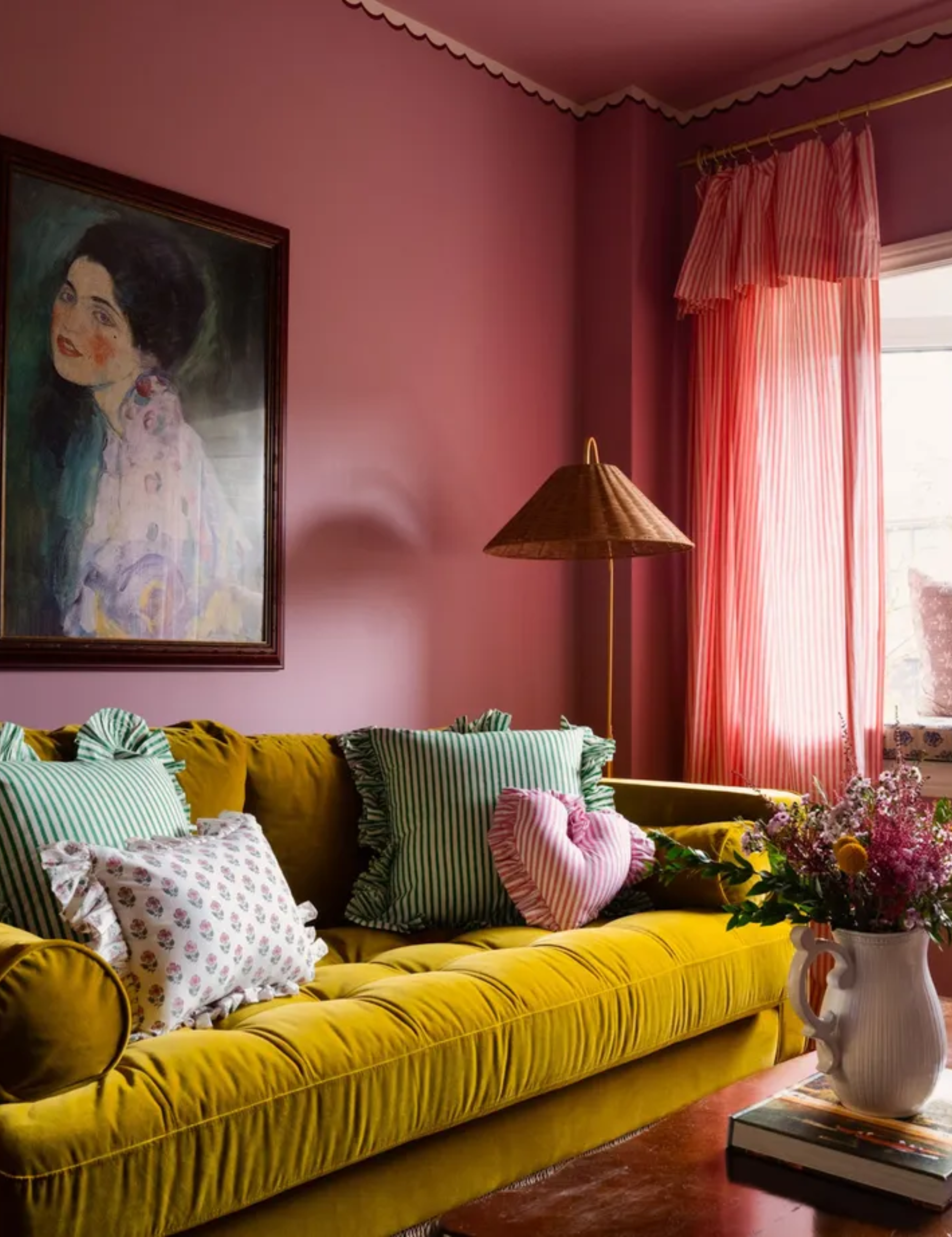living room with dark pink walls and mustard sofa with colorful patterned cushions