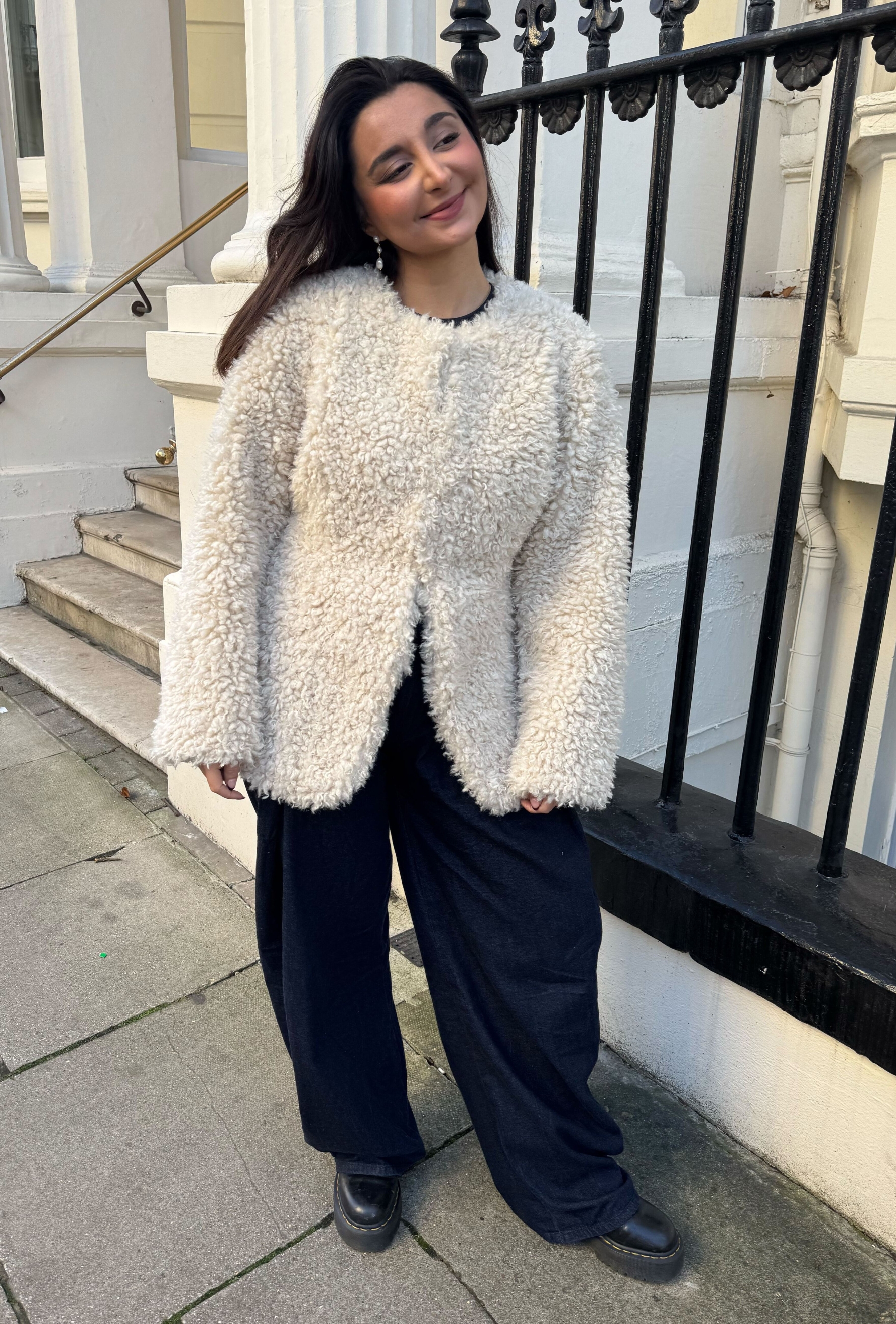 An editor from Who What Wear UK modelling a teddy coat