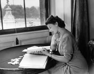 Queen Elizabeth II looking at her stamp collection