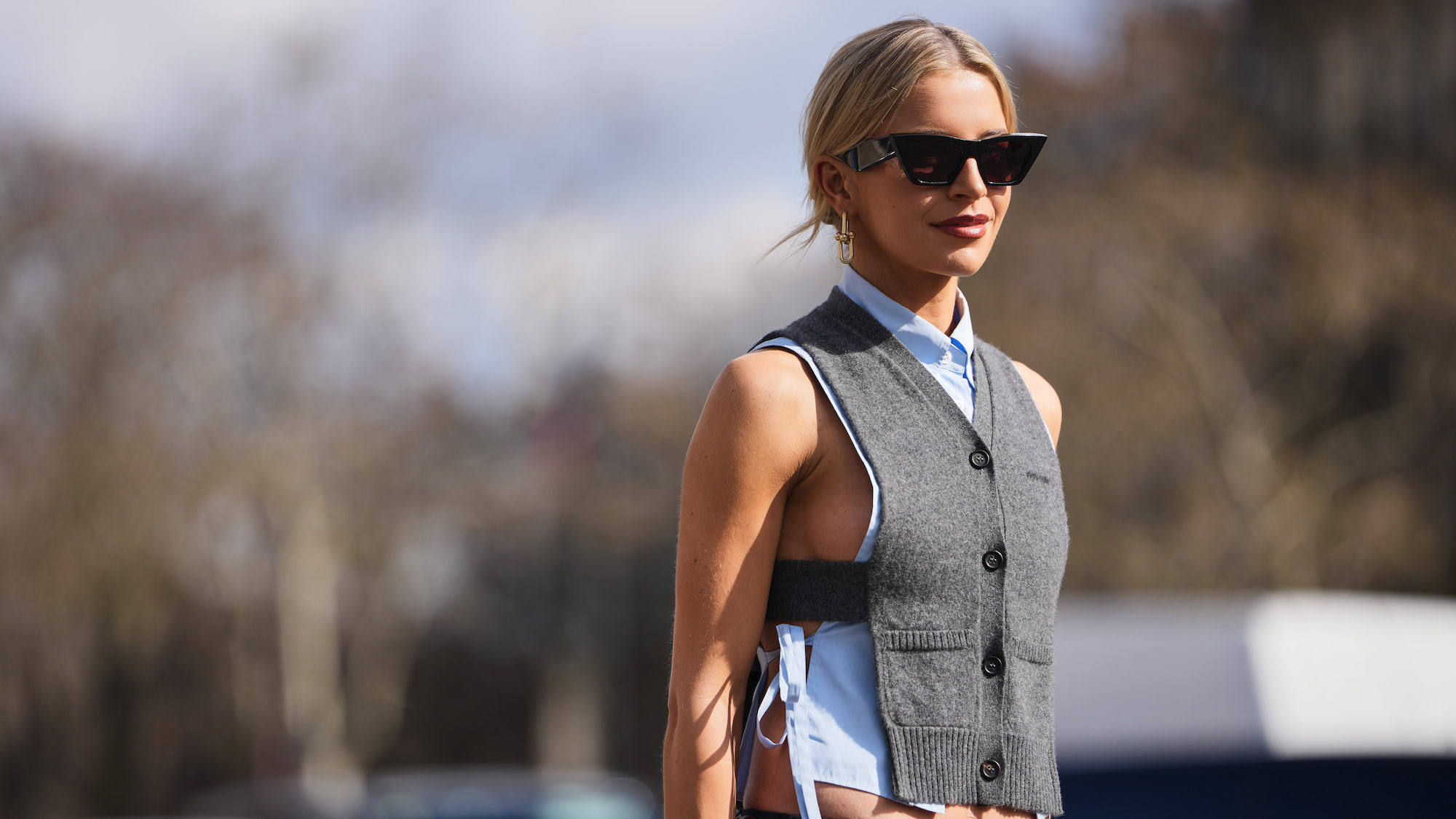 woman with blonde hair, sunglasses and vest in sunshine - best spf for body