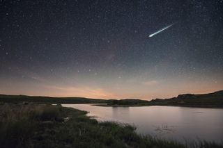 an image of a meteor streaking above a river in Spain