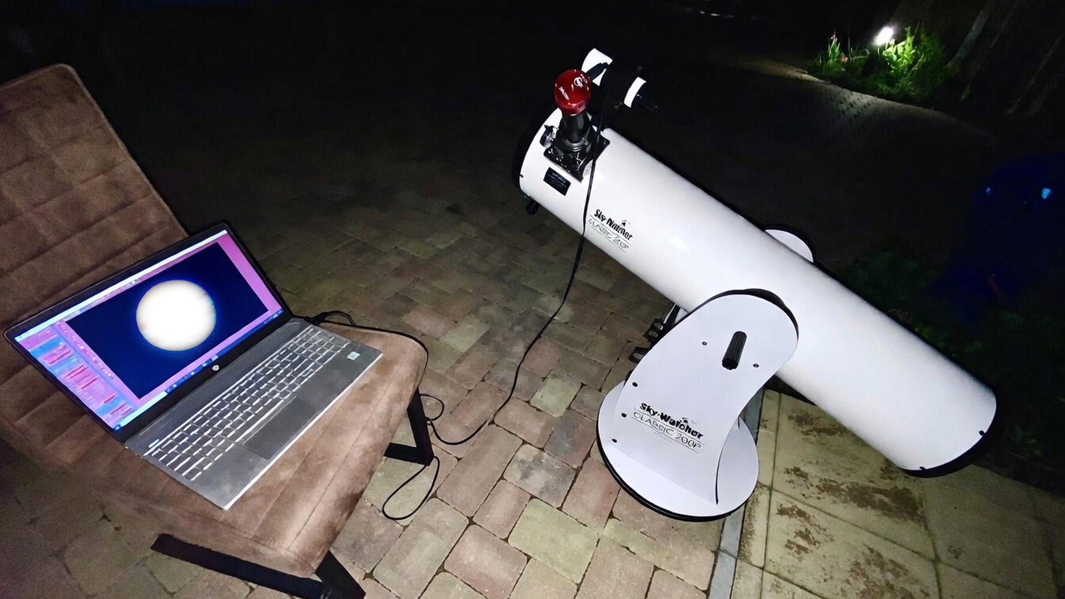 A Sky-Watcher 200P telescope connected, via eyepiece camera, to a laptop. 