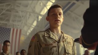 Tom Holland in an Army uniform with the American flag in the background in Cherry.
